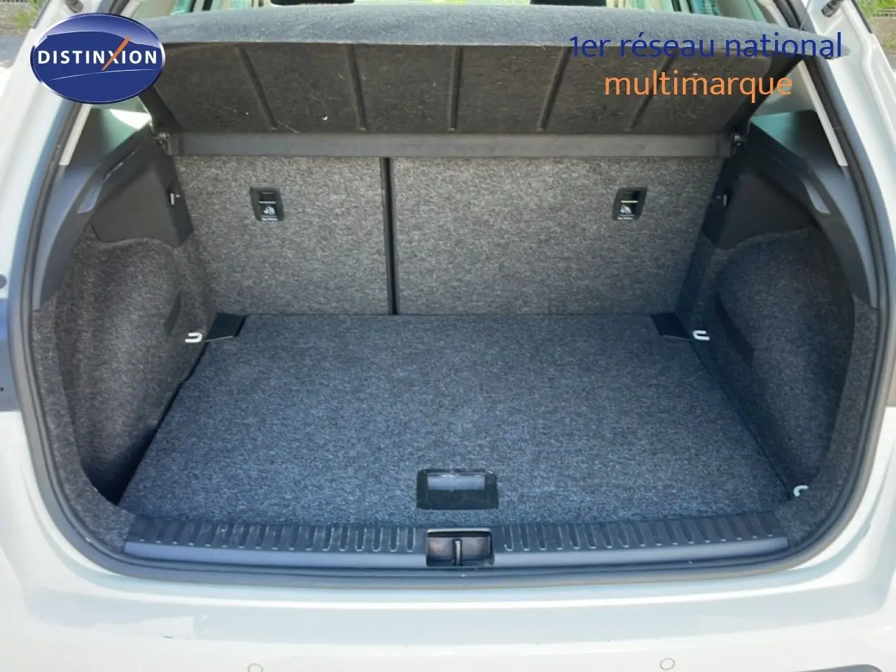 Coffre ouvert vu de l'arrière d'un SEAT Arona blanc métal avec toit noir, montrant un espace de chargement propre et spacieux.