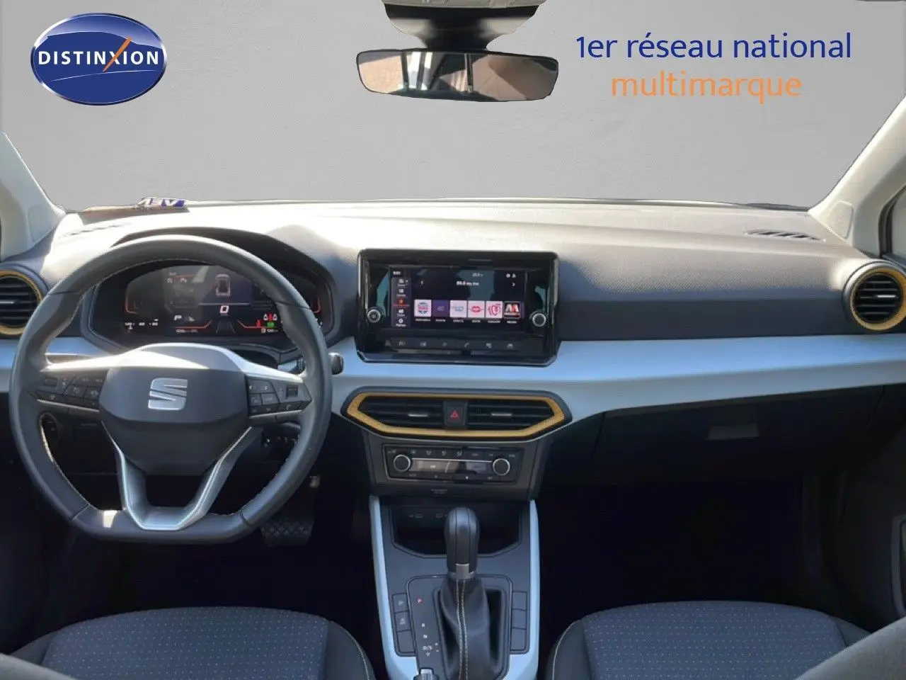 Vue intérieure avant du SEAT Arona blanc métal avec toit noir, tableau de bord moderne et volant multifonction.