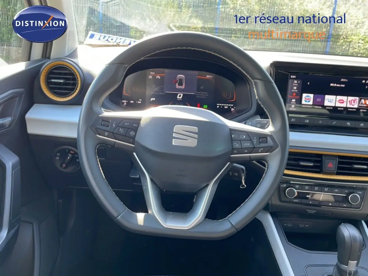 Vue intérieure centrée sur le volant multifonction du SEAT Arona 2025 avec tableau de bord digital et écran tactile.