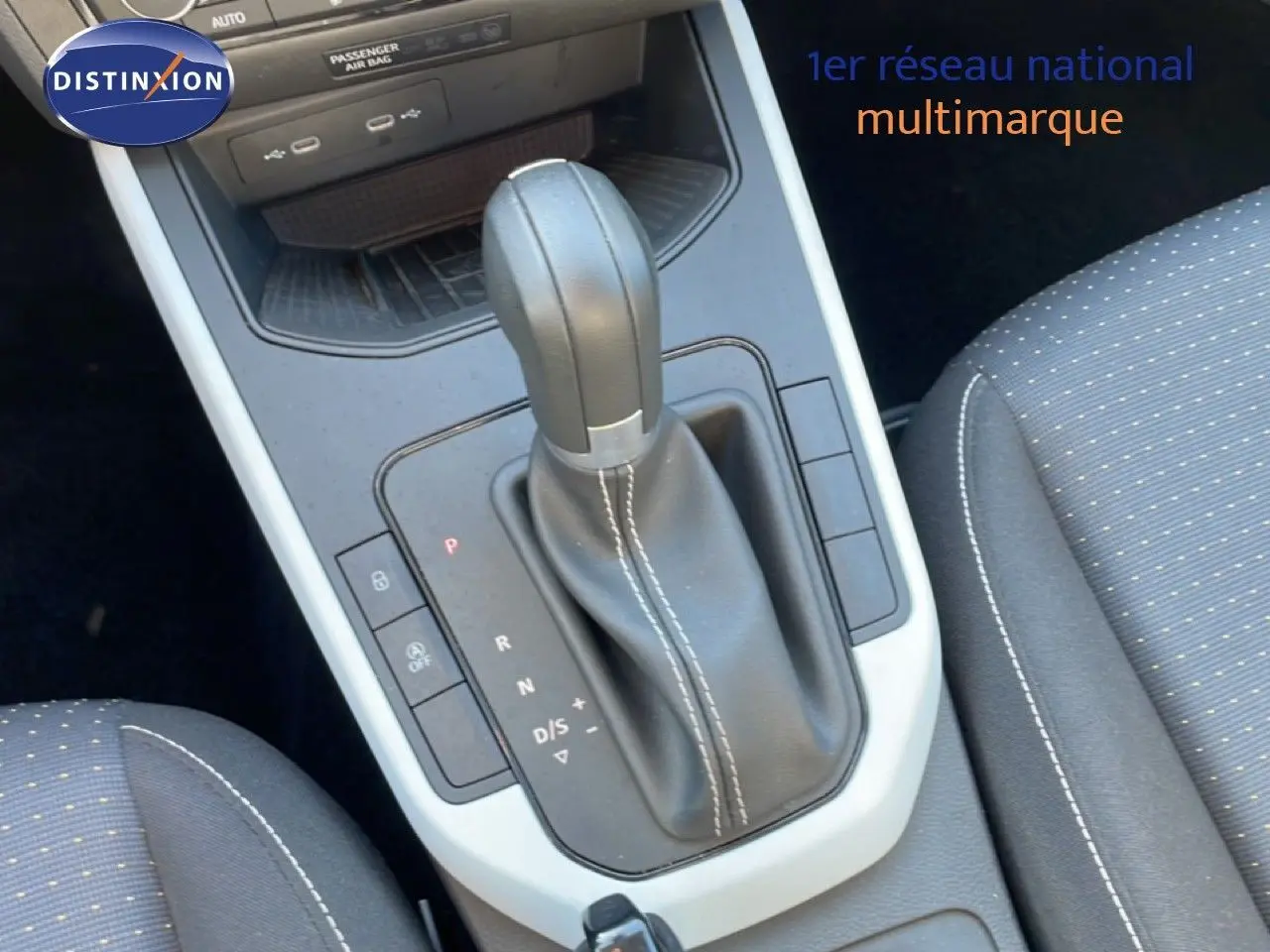 Gros plan sur la console centrale et levier de vitesse automatique en cuir noir avec surpiqûres blanches du SEAT Arona 2025.