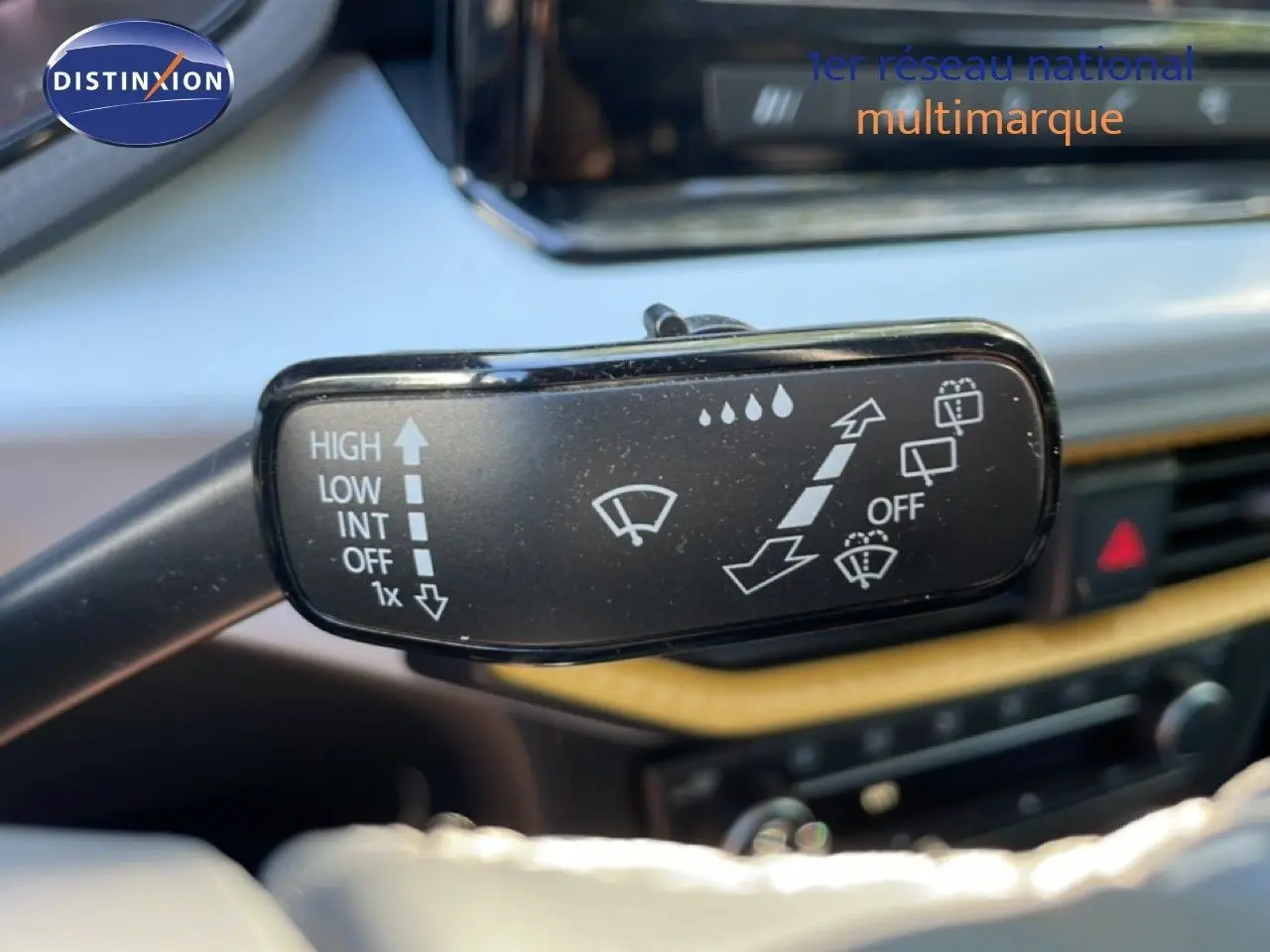 Gros plan sur la commande des essuie-glaces dans l’habitacle d’un SEAT Arona blanc métal avec toit noir.