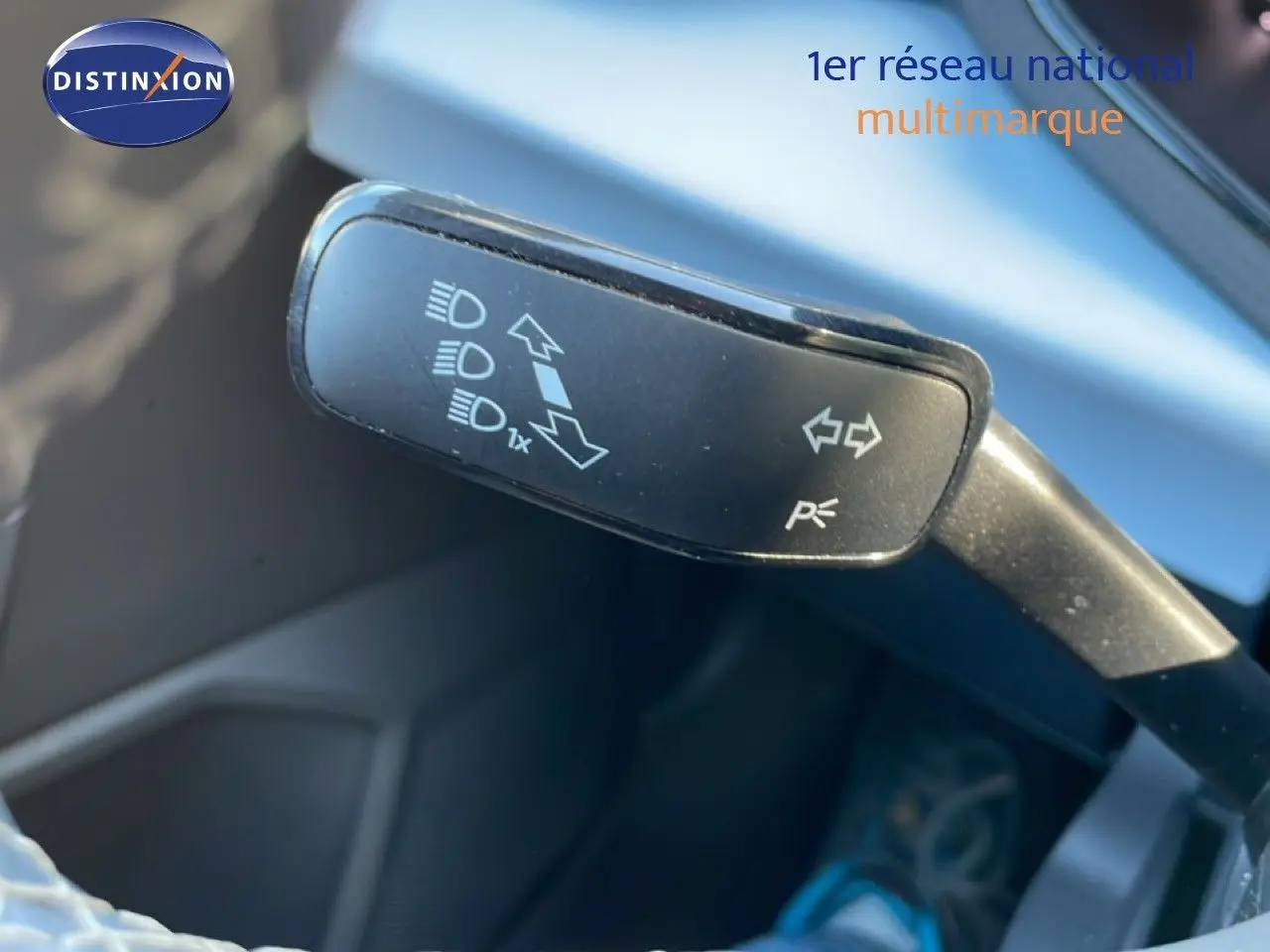 Gros plan sur la manette de clignotant du SEAT Arona 2025, intérieur gris noir, volant partiellement visible.