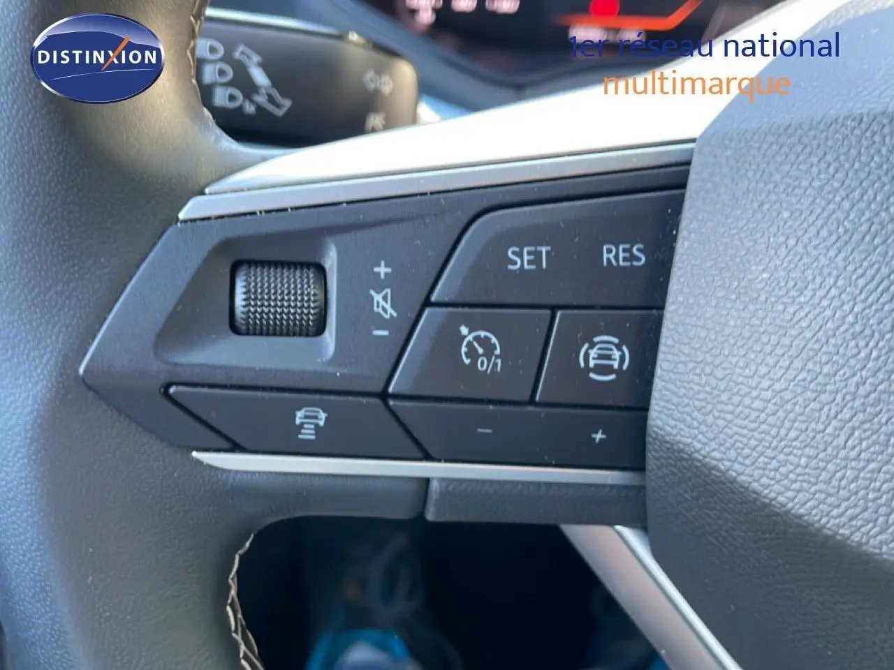 Gros plan sur les commandes au volant du SEAT Arona 2025, volant cuir noir avec boutons de régulateur de vitesse.