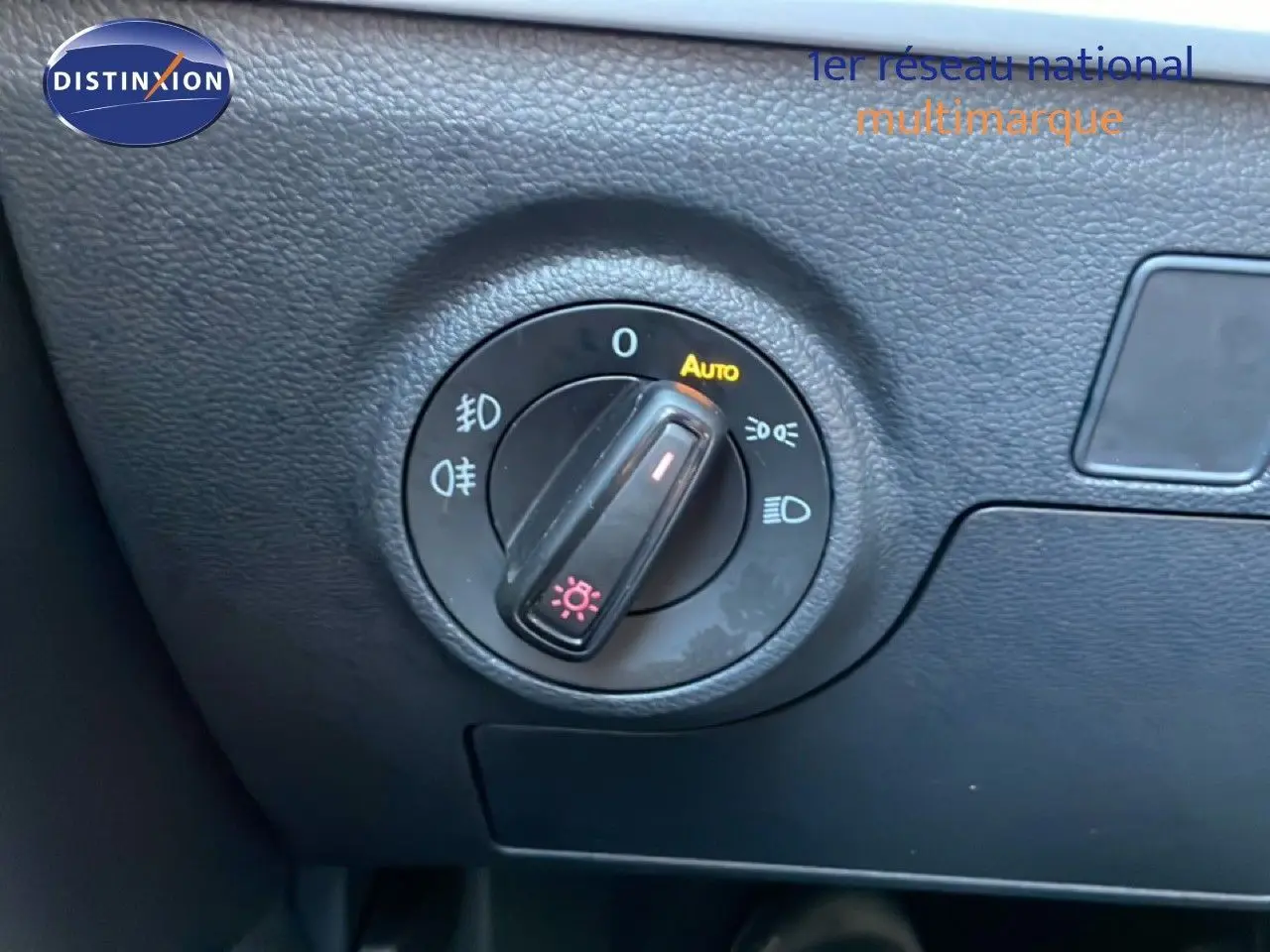 Gros plan sur la molette de réglage des phares dans l’habitacle du SEAT Arona blanc métal avec toit noir.