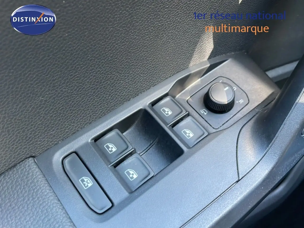 Gros plan sur les commandes de lève-vitres et réglage des rétroviseurs côté conducteur d’un SEAT Arona blanc métal toit noir.