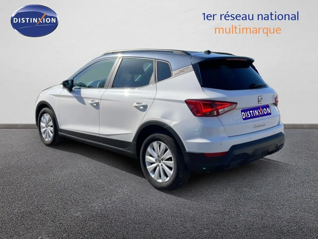 SEAT Arona blanc métal avec toit noir, vue 3/4 arrière côté gauche, sur fond neutre avec logo Distinxion.