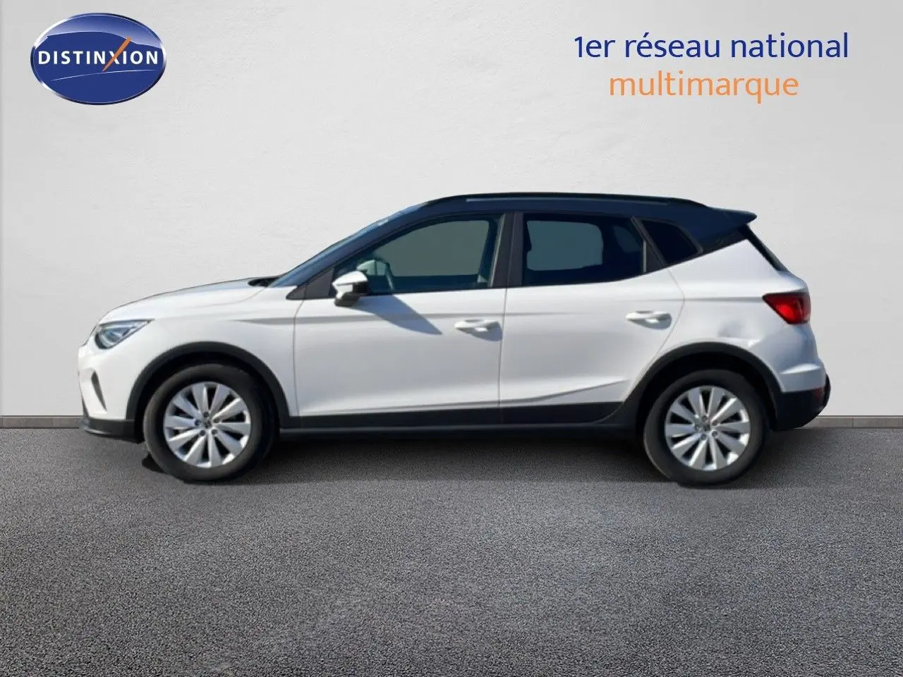 Vue de profil côté gauche d'un SEAT Arona blanc métal avec toit noir, roues alliage et détails noirs sur bas de caisse.