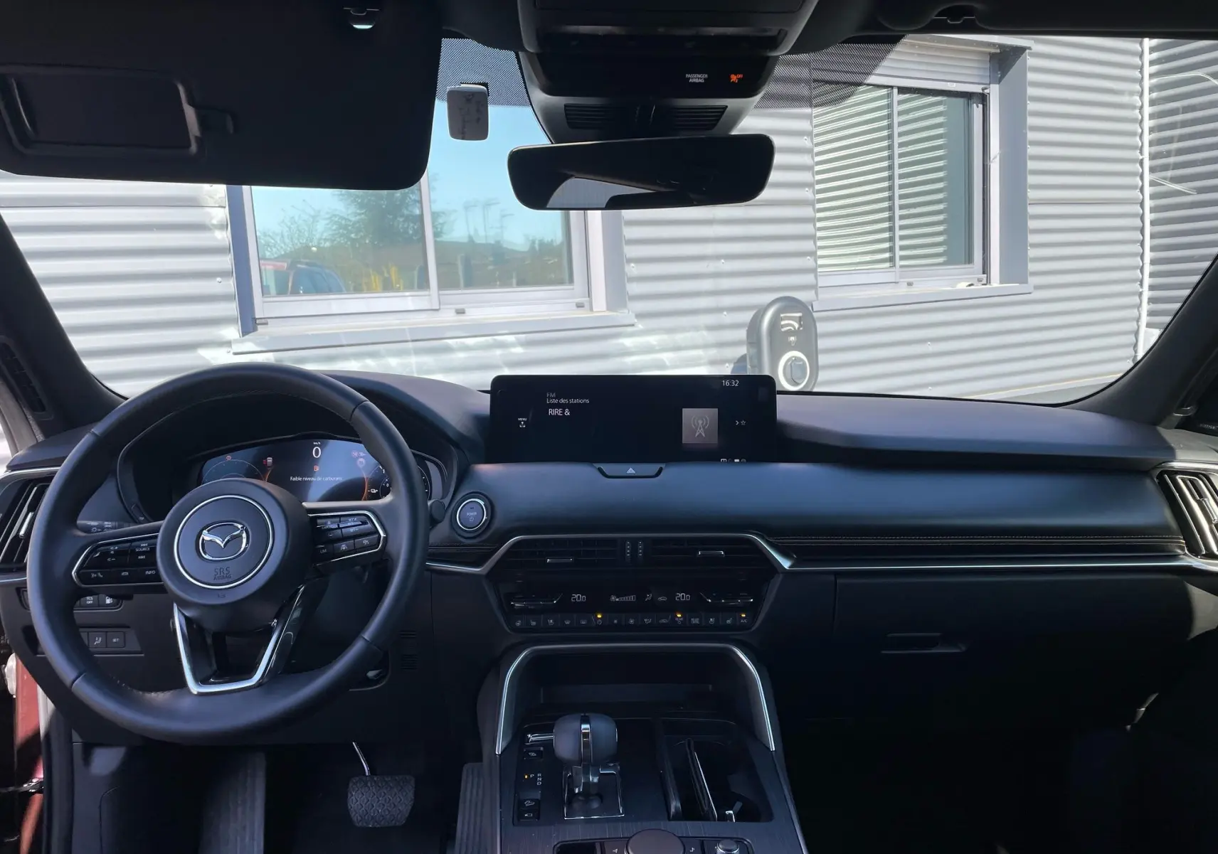Vue intérieure du tableau de bord et volant noir du Mazda CX-80 2024 en finition Homura Pack Ambiance.