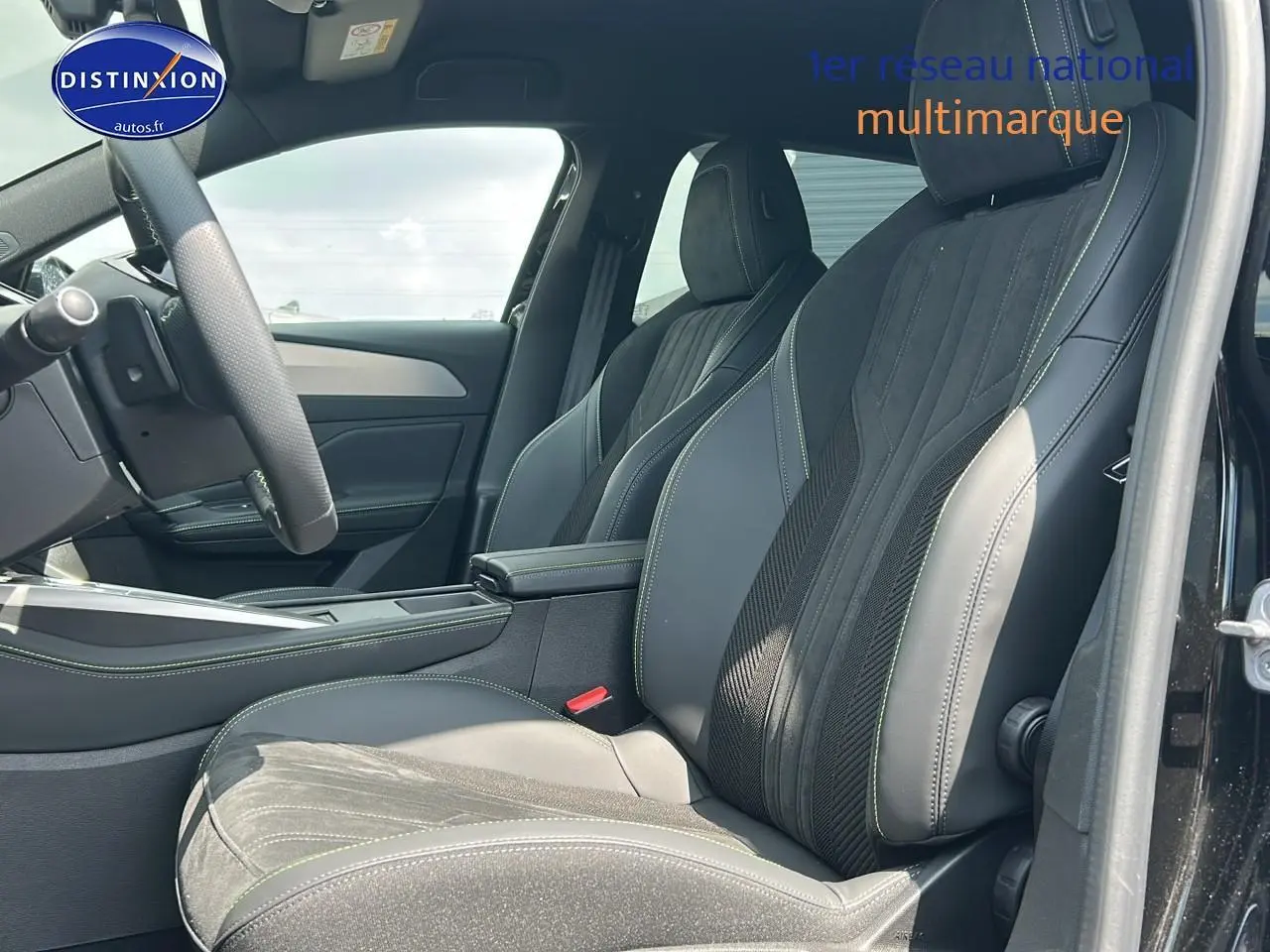 Intérieur de la Peugeot 408 Hybrid 145 GT e-dcs6 2024, vue côté conducteur sur sièges cuir et alcantara noirs avec surpiqûres vertes.