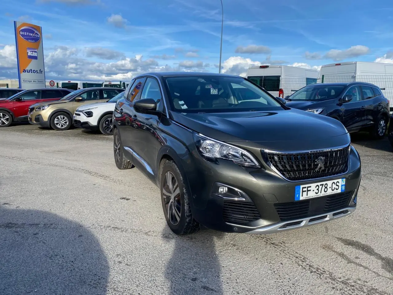Peugeot 3008 gris foncé vue 3/4 avant droit, avec jantes alliage bi-ton et calandre noire brillante.