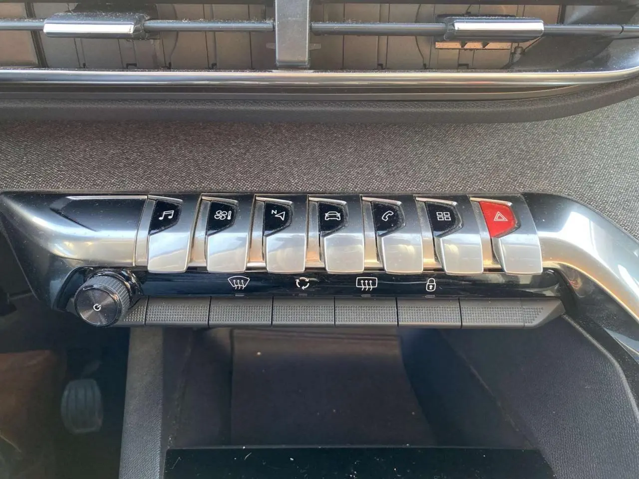 Gros plan sur la rangée de commandes chromées du tableau de bord du Peugeot 3008 gris foncé de 2019.