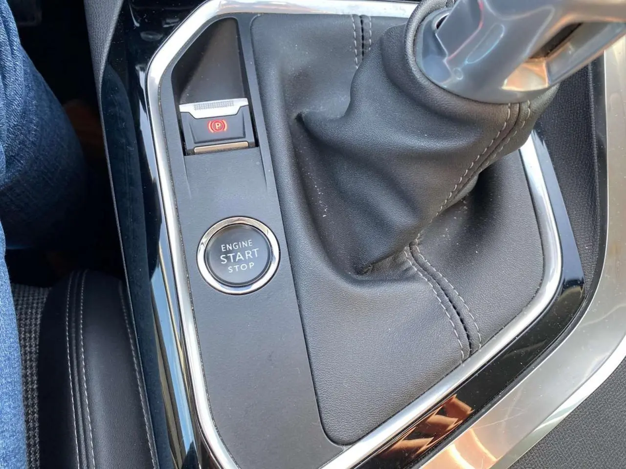 Gros plan sur la console centrale du Peugeot 3008 gris foncé, montrant le levier de vitesse manuel et le bouton start/stop.