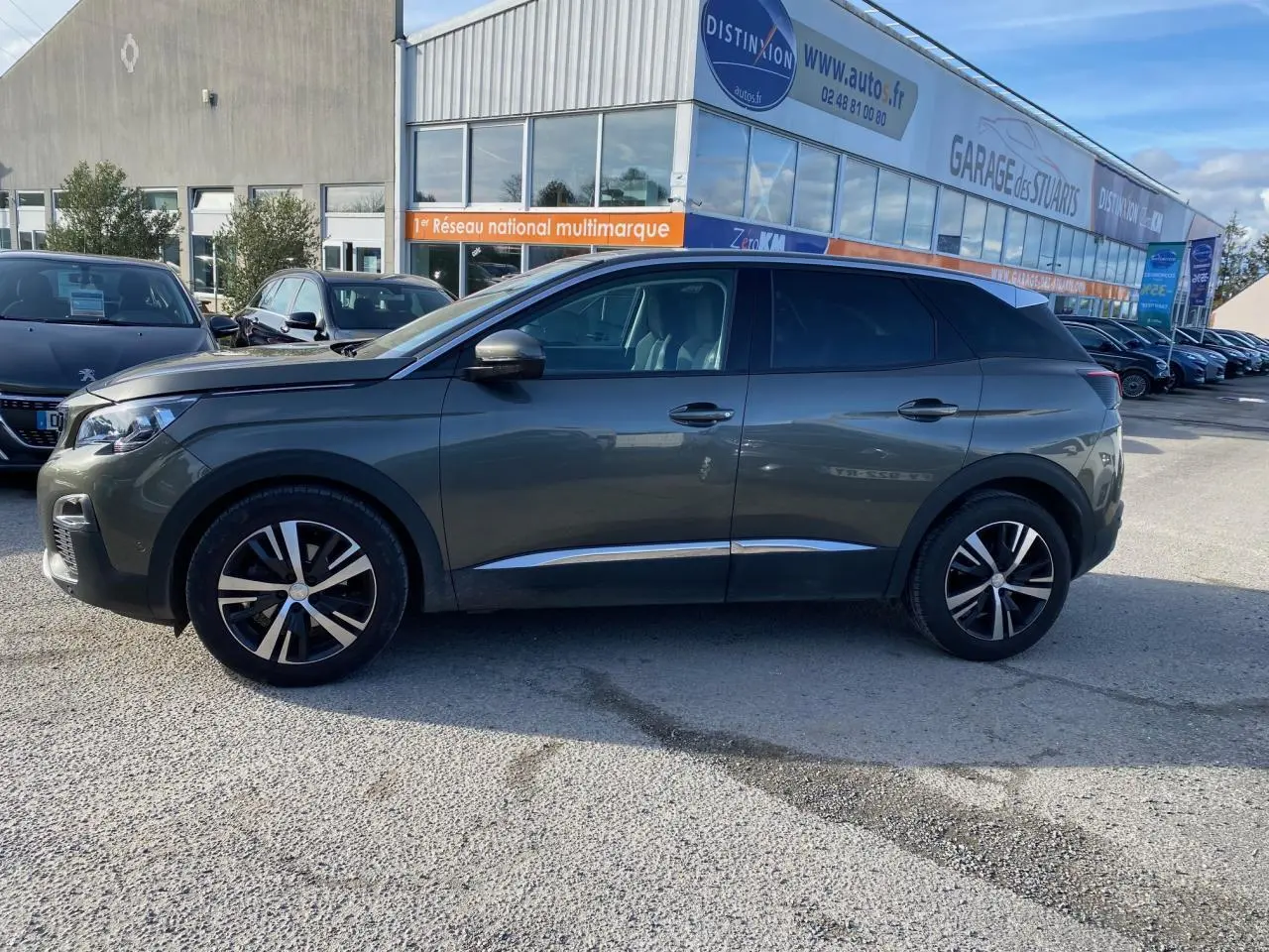 Profil côté gauche d'un Peugeot 3008 gris foncé 2019 avec jantes alliage bi-ton et vitres surteintées.