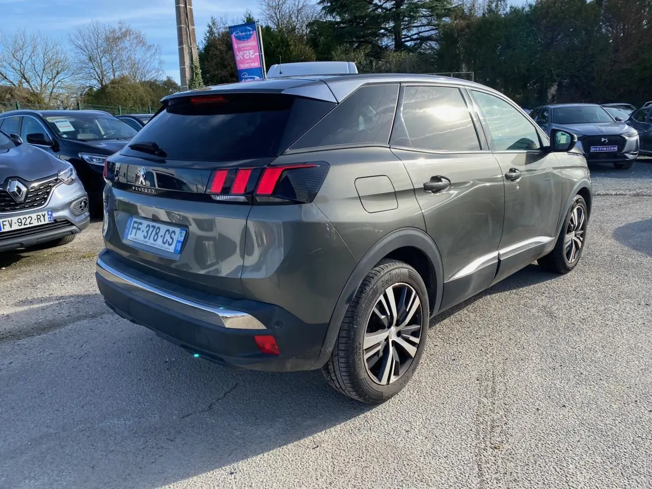 Peugeot 3008 gris foncé vue 3/4 arrière droit, jantes alliage bi-ton et vitres arrière surteintées visibles.