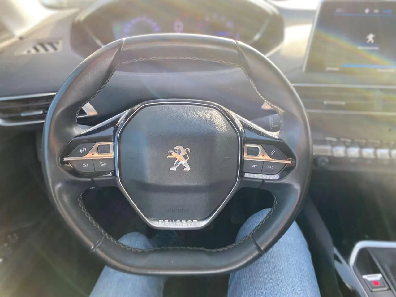 Volant cuir noir du Peugeot 3008 2019 vu de face, avec commandes intégrées et logo lion central argenté.