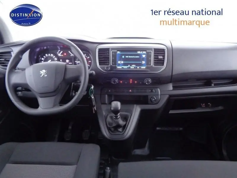 Intérieur du Peugeot Expert Fourgon XL 2023 montrant le tableau de bord, volant avec logo, et levier de vitesses manuel.