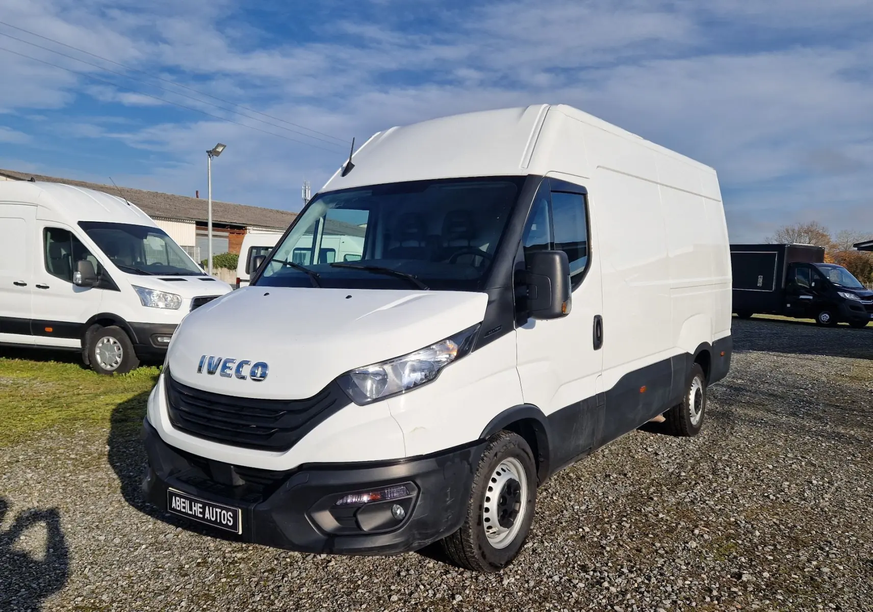 Fourgon Iveco Daily blanc en 3/4 avant droit, avec pare-chocs noir et calandre marquée du logo Iveco.