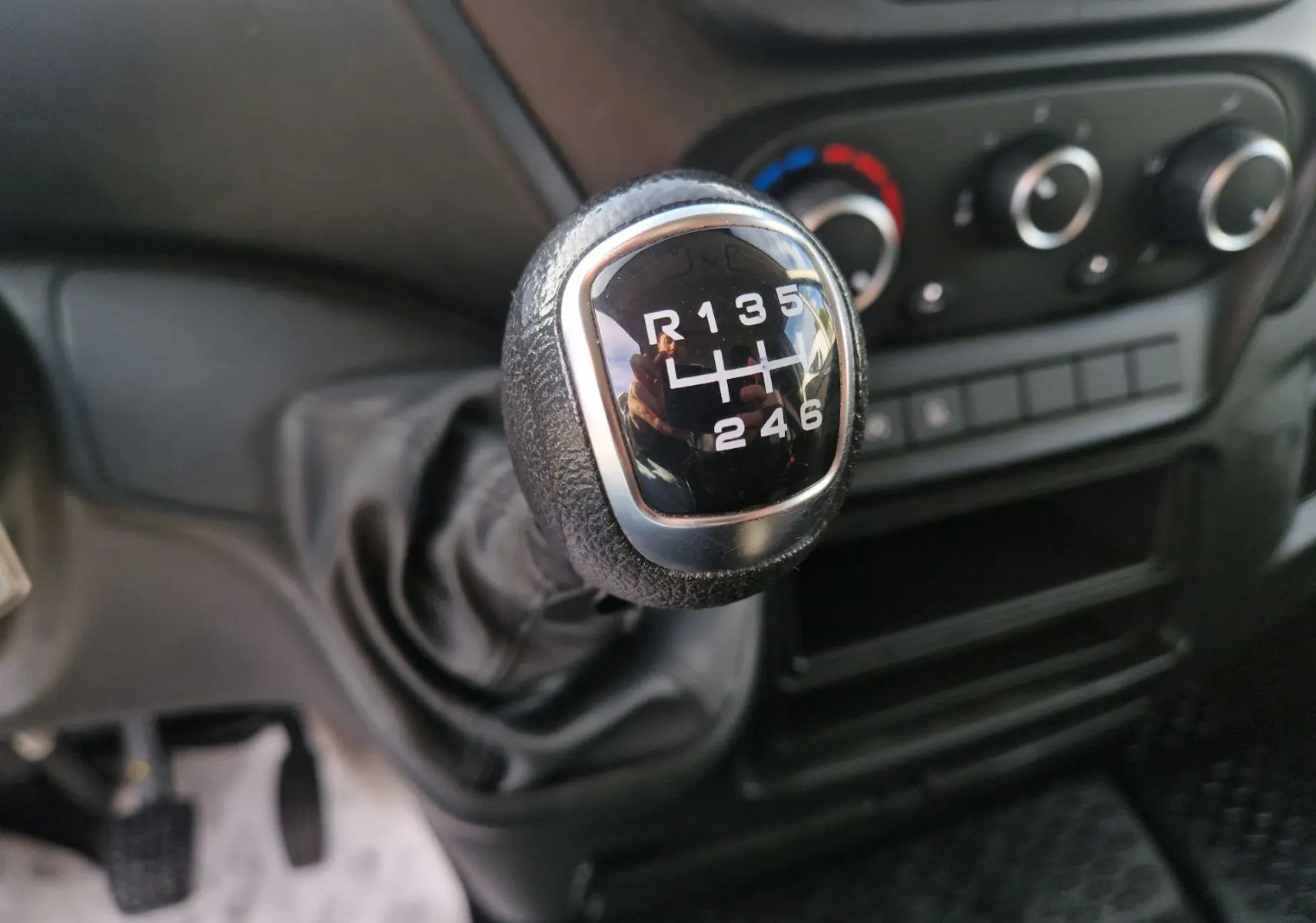 Gros plan sur le levier de vitesses manuel noir de l'Iveco Daily Fourgon 2023, avec tableau de bord en arrière-plan.