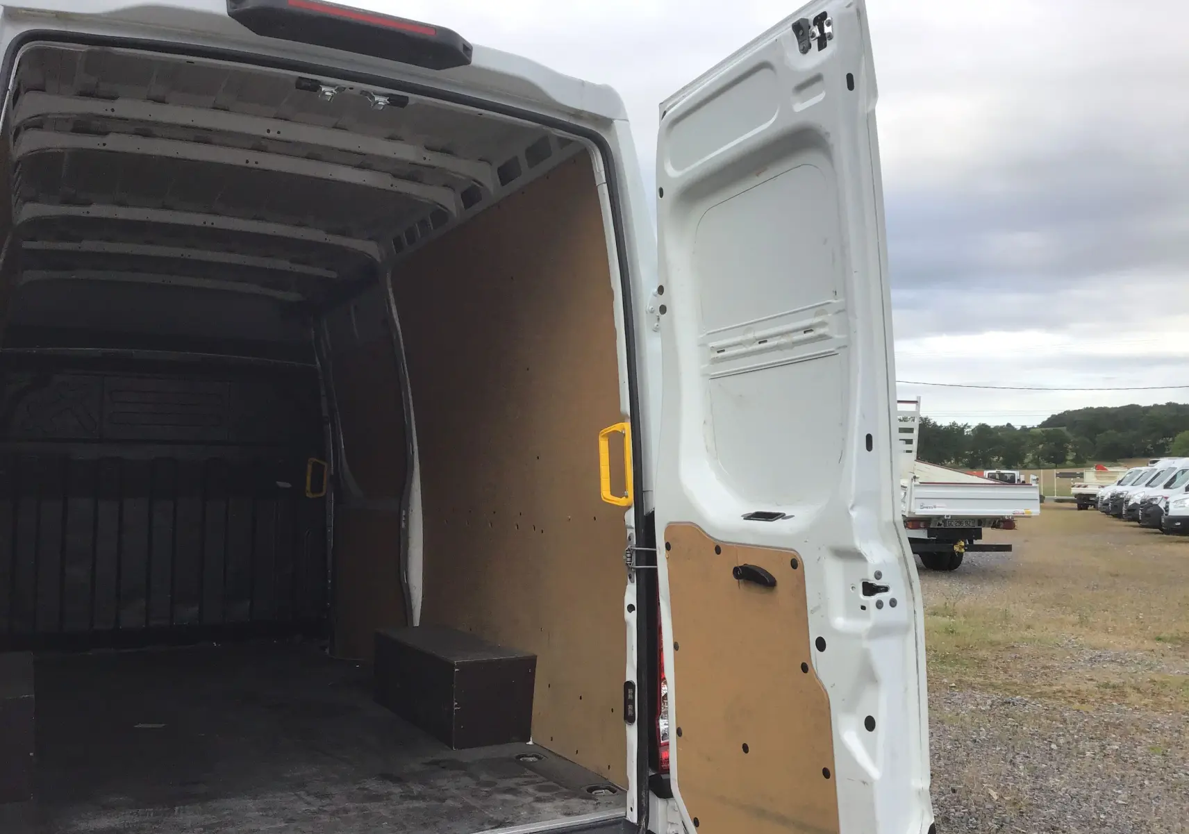 Vue arrière ouverte du fourgon blanc Iveco Daily 35S16 2023, montrant l’intérieur vide avec parois en bois.