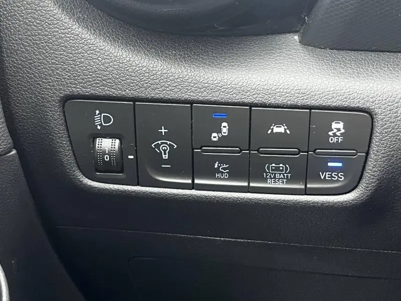 Gros plan sur les commandes de sécurité et assistance du tableau de bord d’une Hyundai Kona bleu 2020 hybride.
