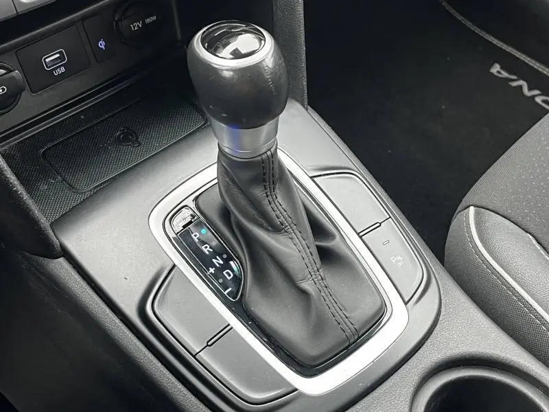 Gros plan sur le levier de vitesses automatique noir de la Hyundai Kona hybride 2020, avec console centrale grise.