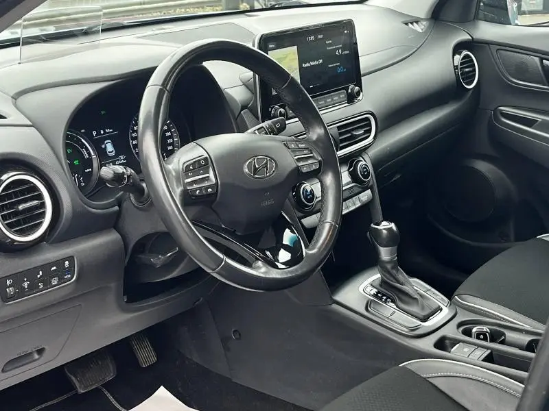 Vue intérieure côté conducteur du Hyundai Kona 2020, volant cuir multifonction et écran tactile central visible.