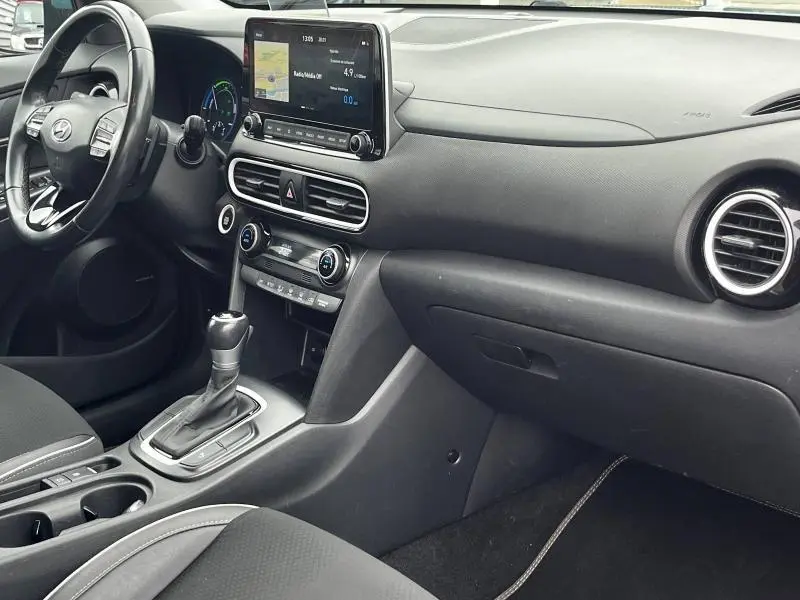 Vue intérieure côté passager du tableau de bord noir du Hyundai Kona 1.6 GDi hybrid avec écran tactile et volant cuir multifonction.
