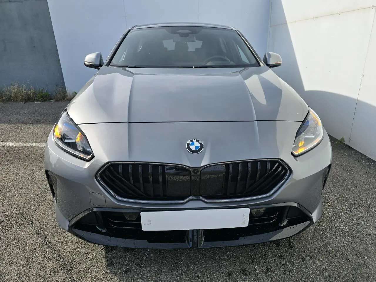 Vue frontale d'une BMW Série 1 120 M Sport gris Skyscraper avec calandre noire et toit noir visible.