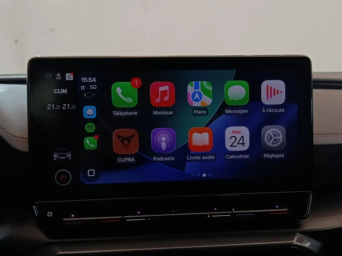 Écran tactile central de la CUPRA Formentor 2024 affichant Apple CarPlay avec fond noir et détails lumineux.