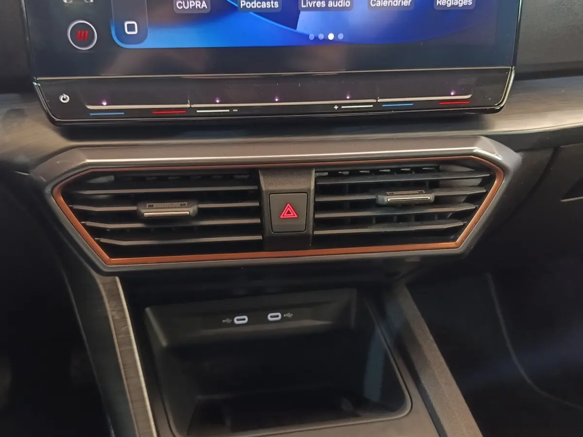 Détail du tableau de bord noir de la CUPRA Formentor 2024, avec écran tactile et aérateurs encadrés de cuivre.