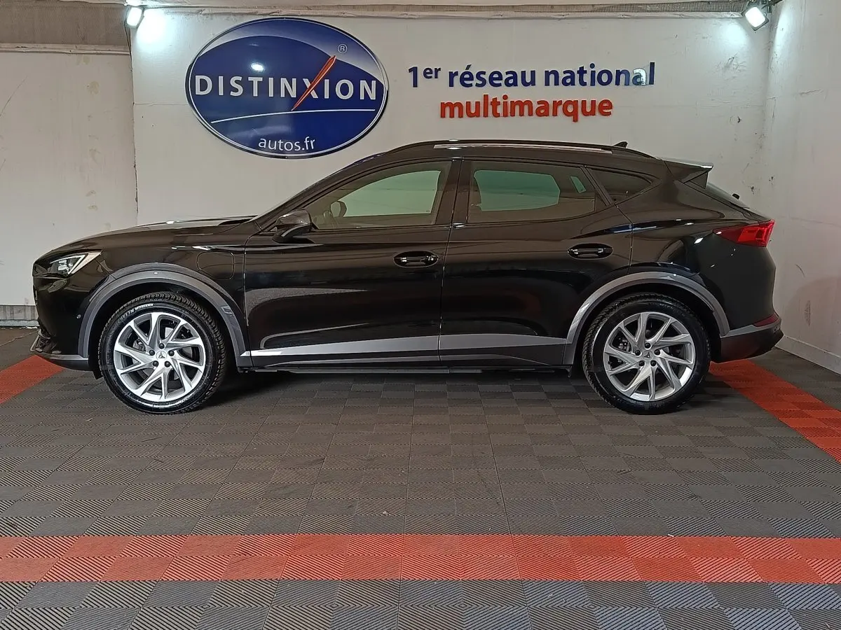 Profil droit d'un CUPRA Formentor noir 2024 avec rails de toit et jantes argentées, en intérieur showroom.