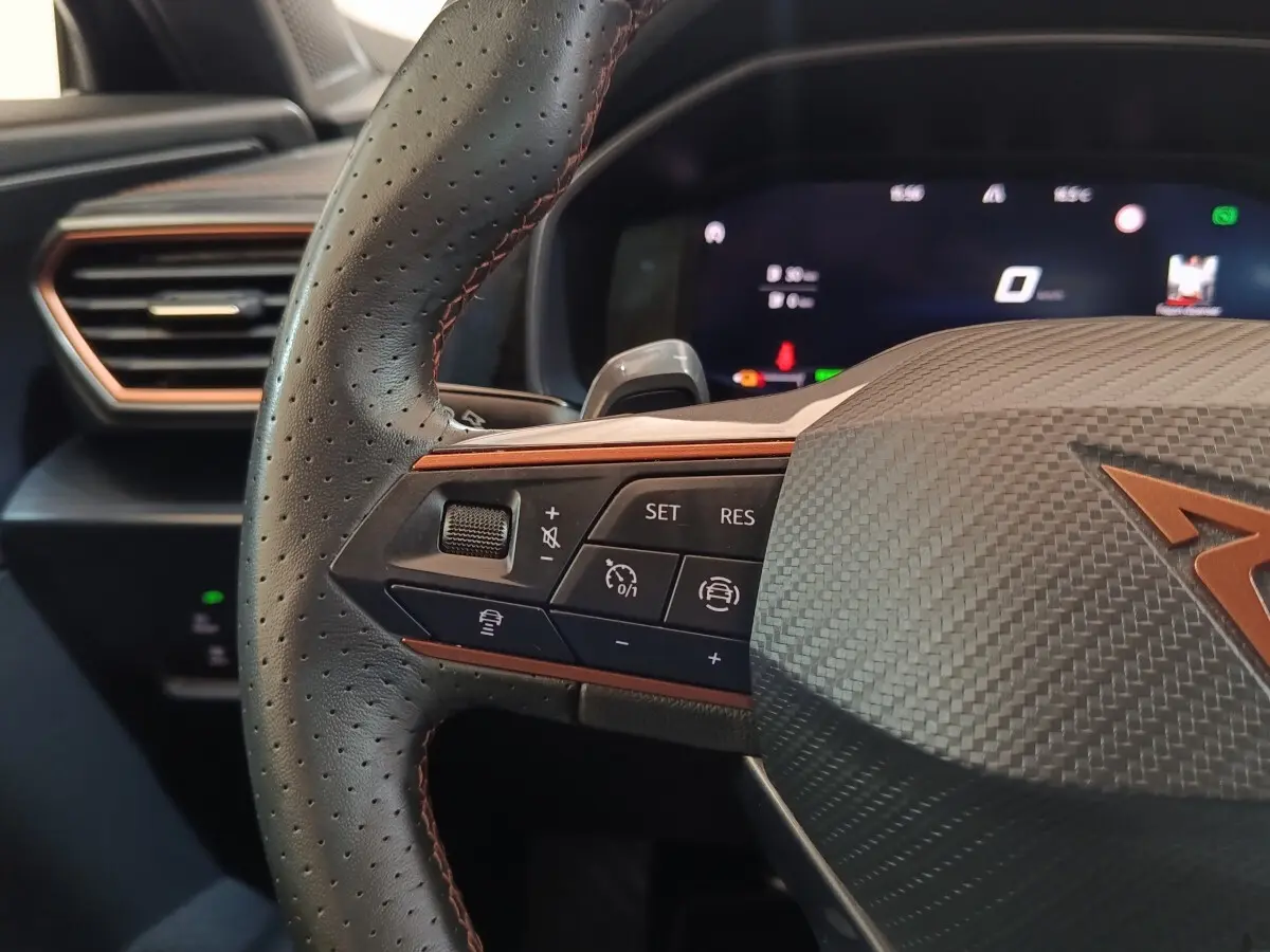 Gros plan sur le volant noir perforé avec surpiqûres cuivrées et commandes multifonctions du CUPRA Formentor 2024.