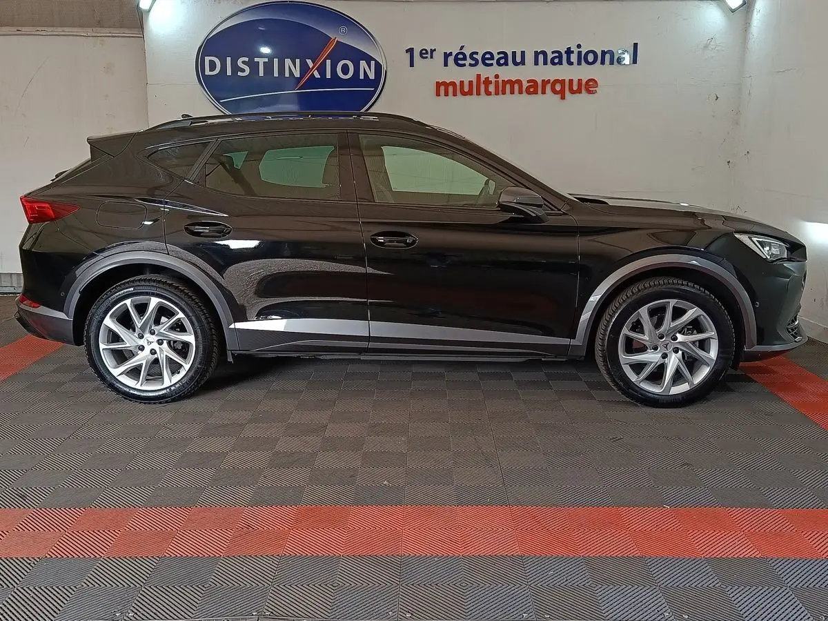 Vue latérale droite d'un CUPRA Formentor noir 2024 avec rails de toit assortis et jantes argentées en showroom.