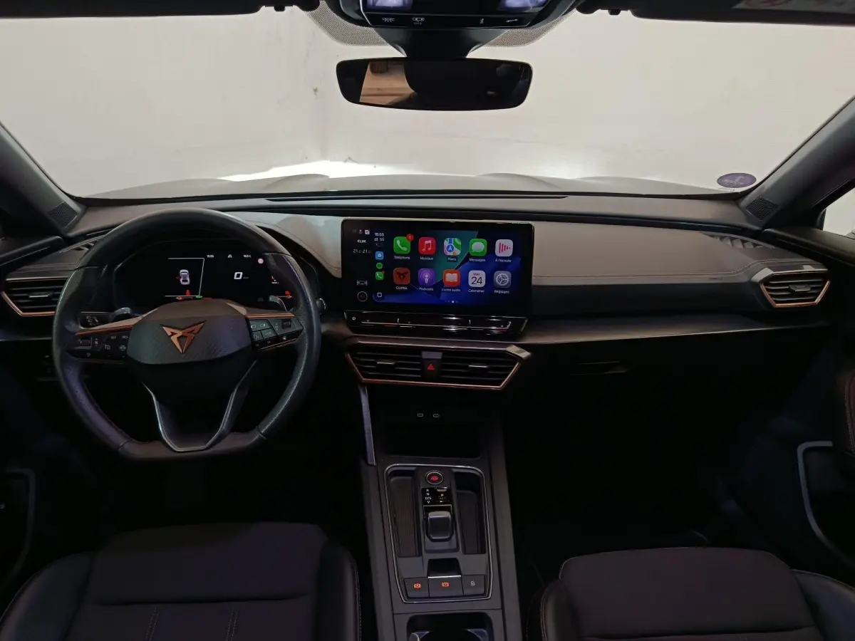 Vue intérieure frontale du tableau de bord noir du CUPRA Formentor 1.4 e-HYBRID avec écran tactile central allumé.