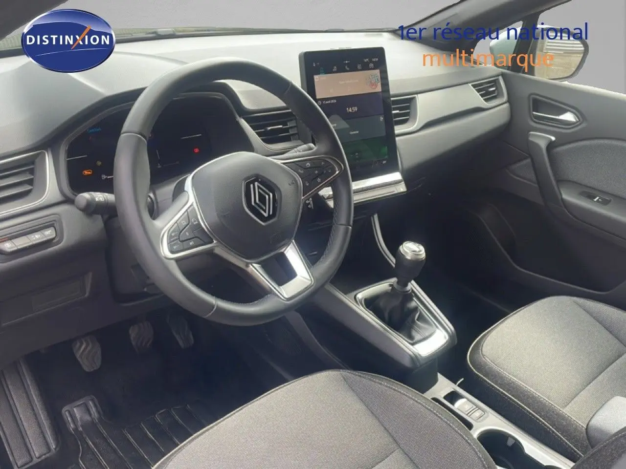 Vue intérieure côté conducteur du Renault Captur 2025, tableau de bord moderne avec écran tactile vertical et volant cuir multifonction.