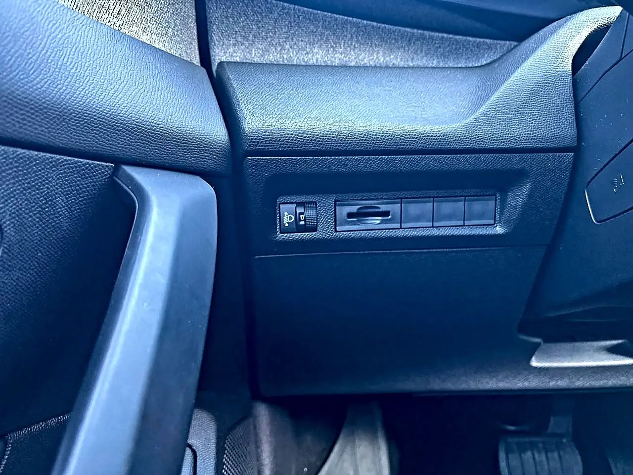 Détail du tableau de bord côté gauche noir du Peugeot 308 1.5 BlueHDi 130 Allure 2025 avec commande éclairage.