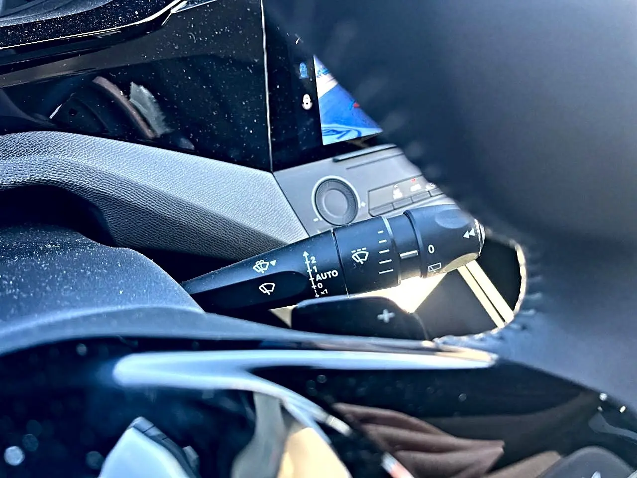 Gros plan sur la commande d’essuie-glace côté droit du volant dans l’habitacle noir de la Peugeot 308 2025.