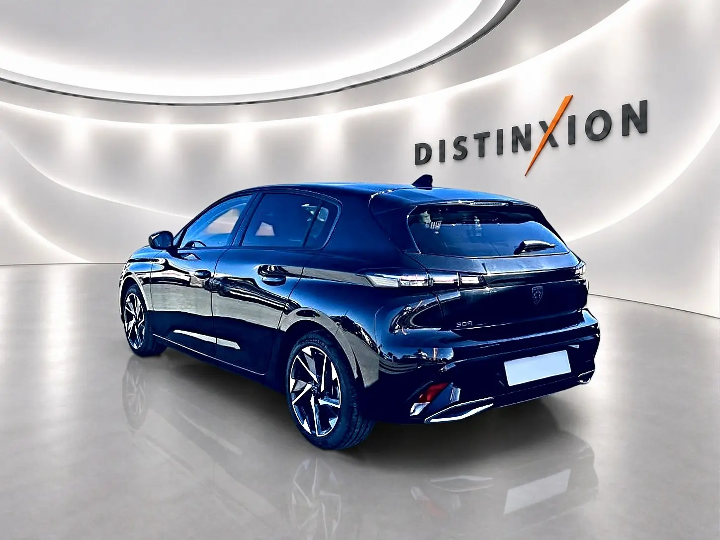Peugeot 308 noire vue 3/4 arrière droit en intérieur, avec jantes alliage et feux arrière LED distinctifs.