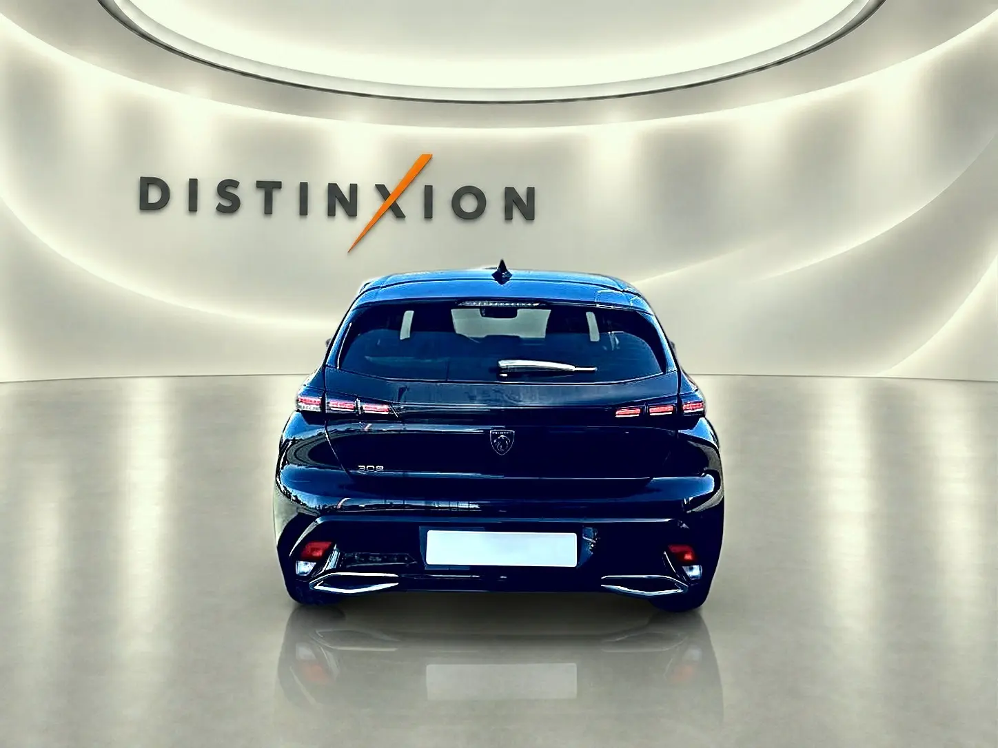 Vue arrière d'une Peugeot 308 noire 2025 avec feux LED et logo distinctif dans un showroom lumineux.