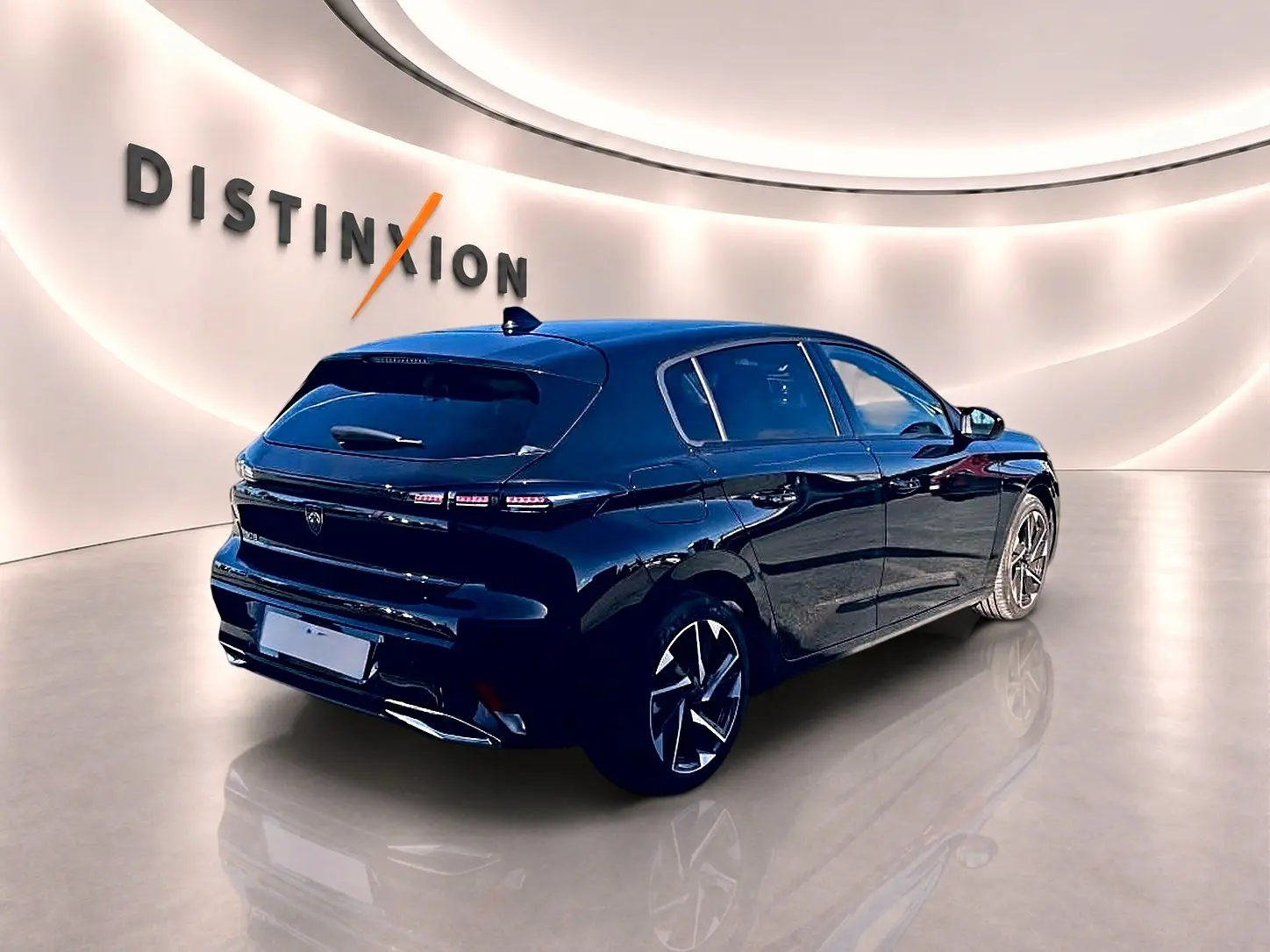 Peugeot 308 noire vue en 3/4 arrière droit dans un showroom avec jantes alliage et feux arrière LED.