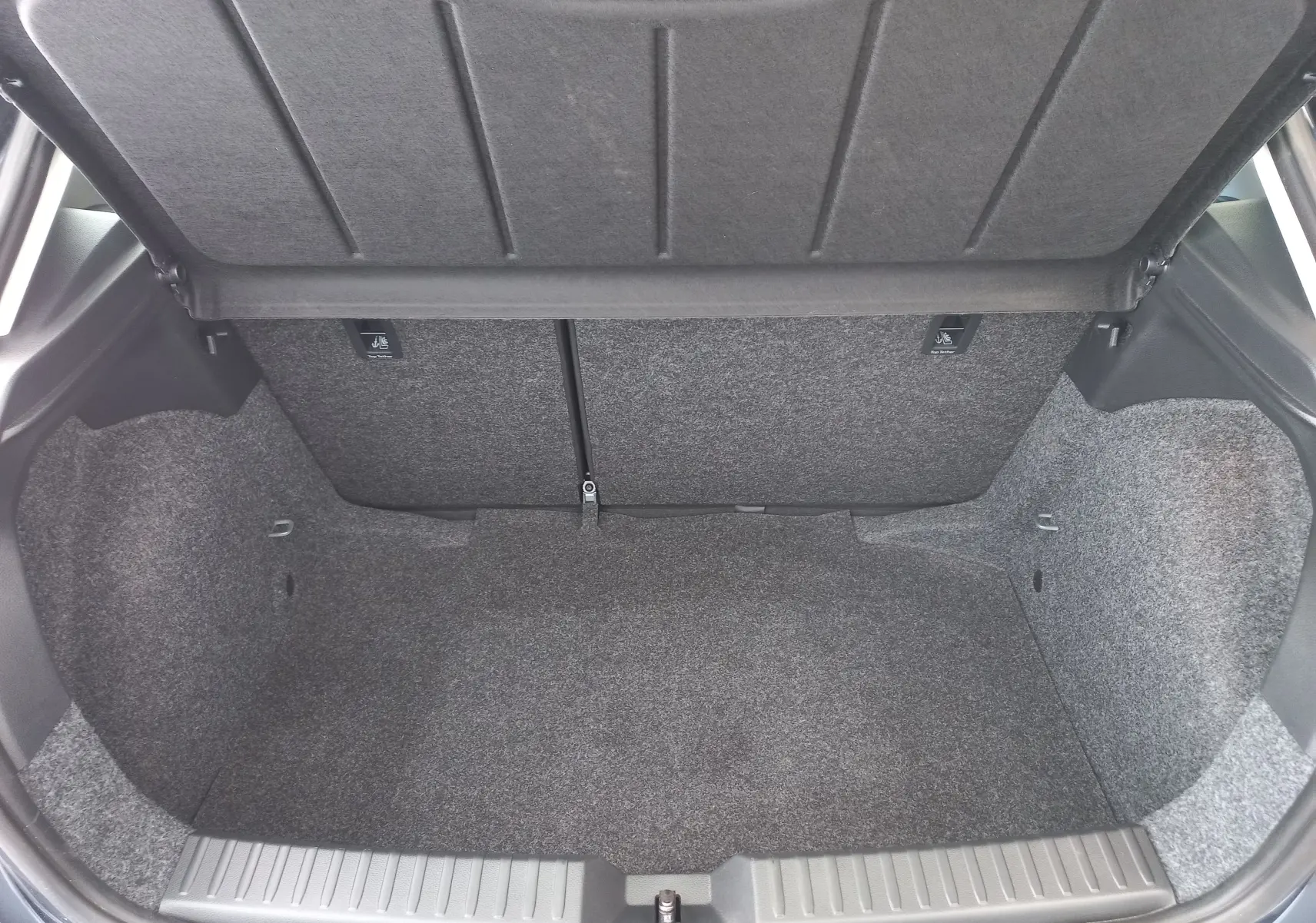 Coffre ouvert vu de l'arrière d'une SEAT Ibiza 1.0 TSI 115 DSG7 Copa 2025, revêtement intérieur gris.