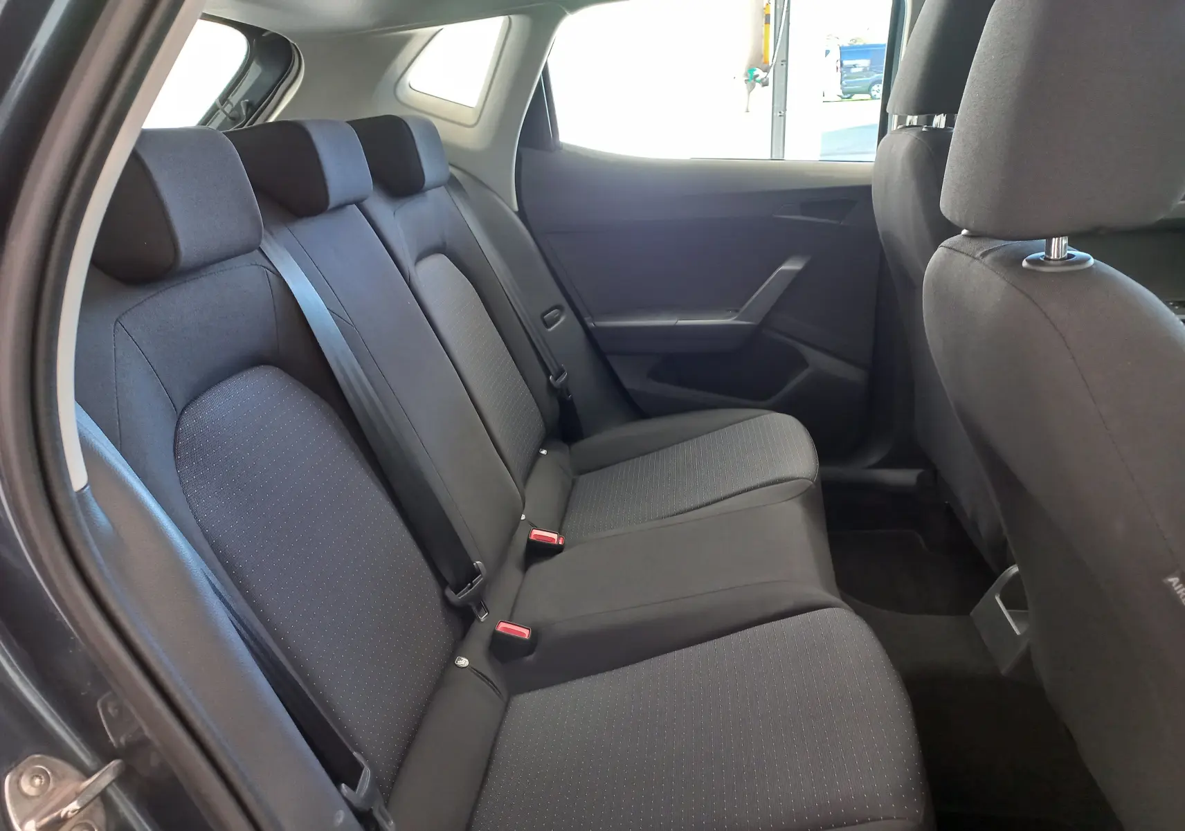 Vue intérieure côté gauche des sièges arrière noirs en tissu de la SEAT IBIZA 1.0 TSI 115 DSG7 COPA gris magnétique 2025.