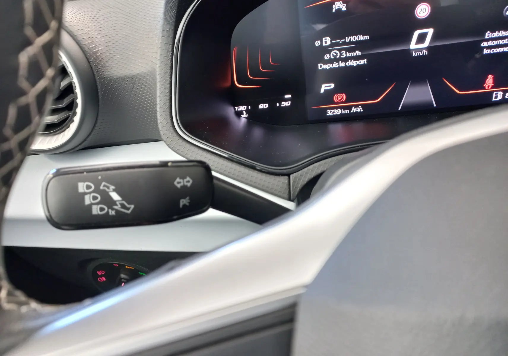Tableau de bord numérique et commodo des feux dans l'habitacle d'une SEAT Ibiza gris magnétique 2025, vue rapprochée côté conducteur.