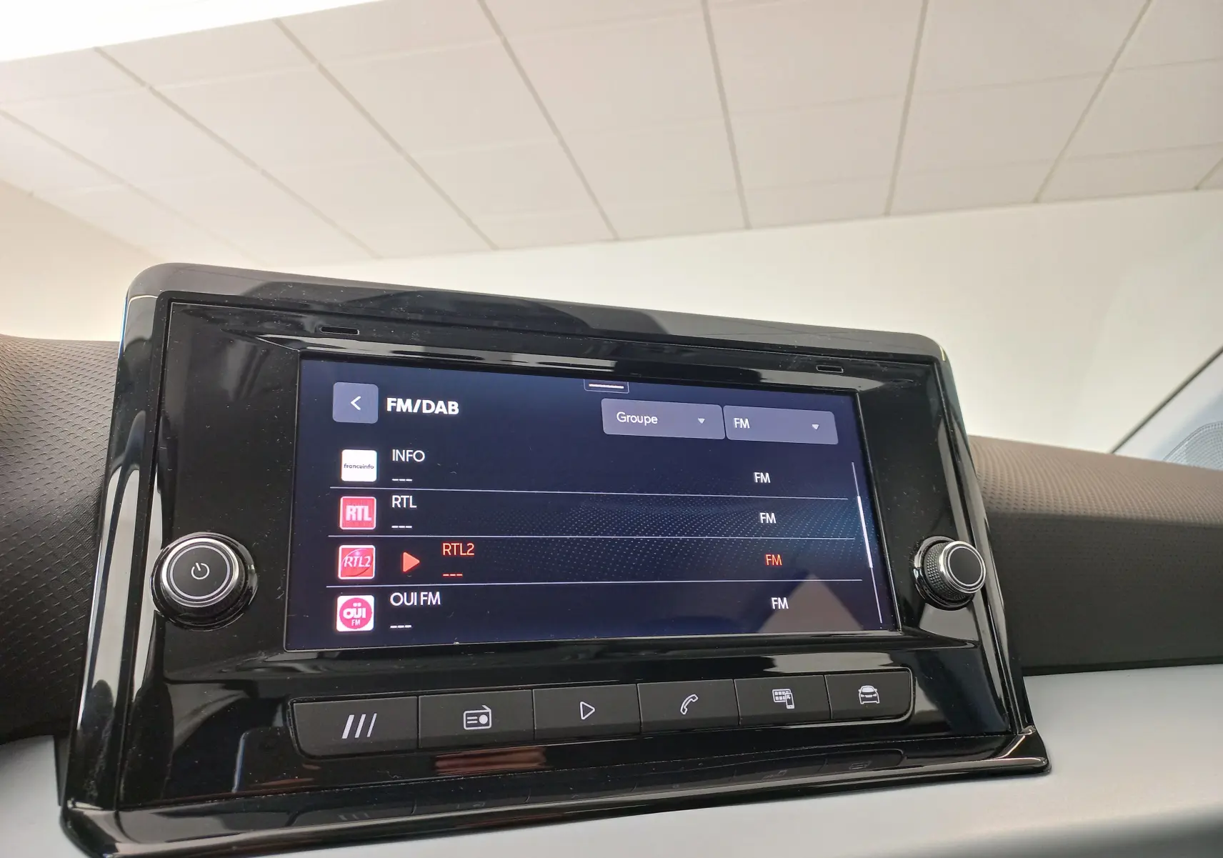 Écran tactile central de la SEAT IBIZA 2025 affichant les stations FM/DAB, entouré de boutons de contrôle noirs.