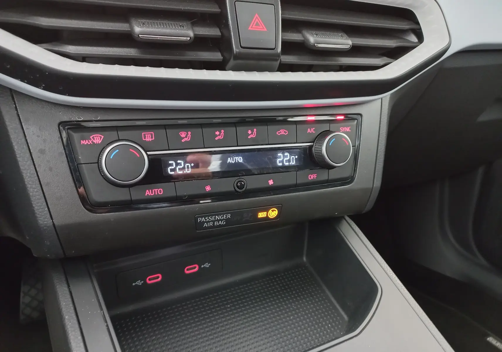 Vue rapprochée du tableau de bord du SEAT Ibiza 2025 gris magnétique, montrant la climatisation automatique et ports USB.