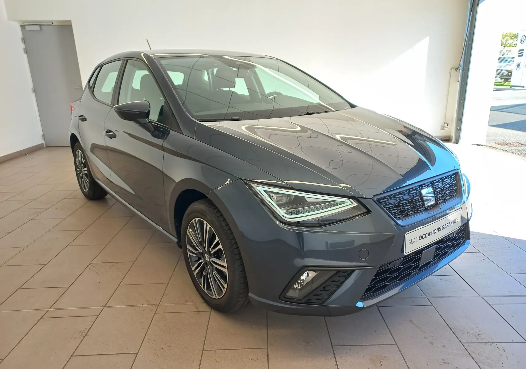 SEAT Ibiza 1.0 TSI 115 DSG7 Copa gris magnétique vue 3/4 avant droit en intérieur avec phares LED distinctifs.