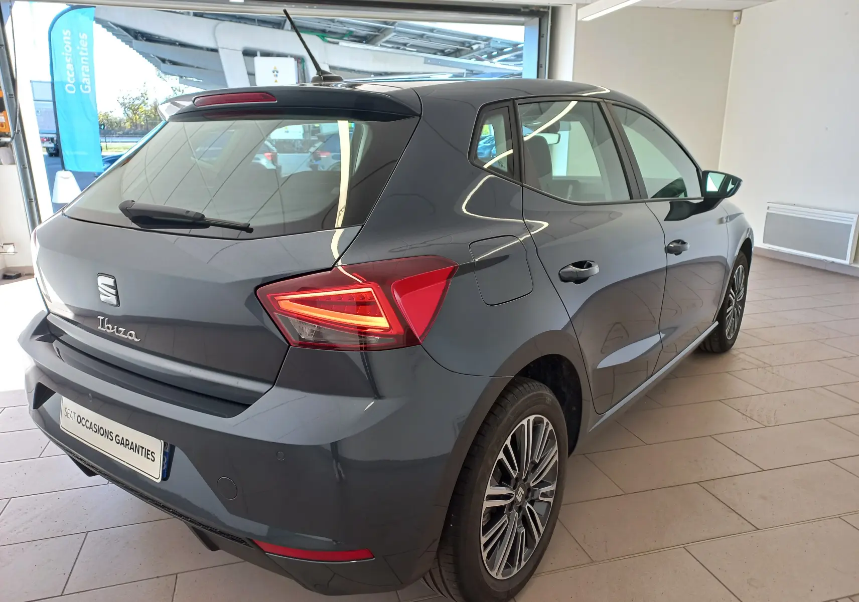 SEAT Ibiza 1.0 TSI 115 DSG7 Copa gris magnétique vue 3/4 arrière droit en intérieur showroom.