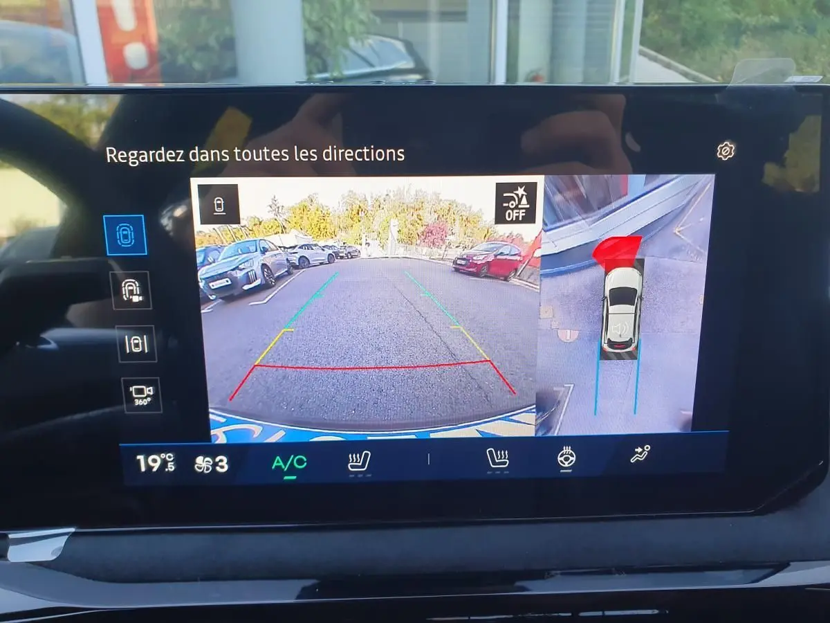 Écran de caméra de recul et vue 360° du stationnement d’une Renault Clio VI rouge Absolu, affichage intérieur.