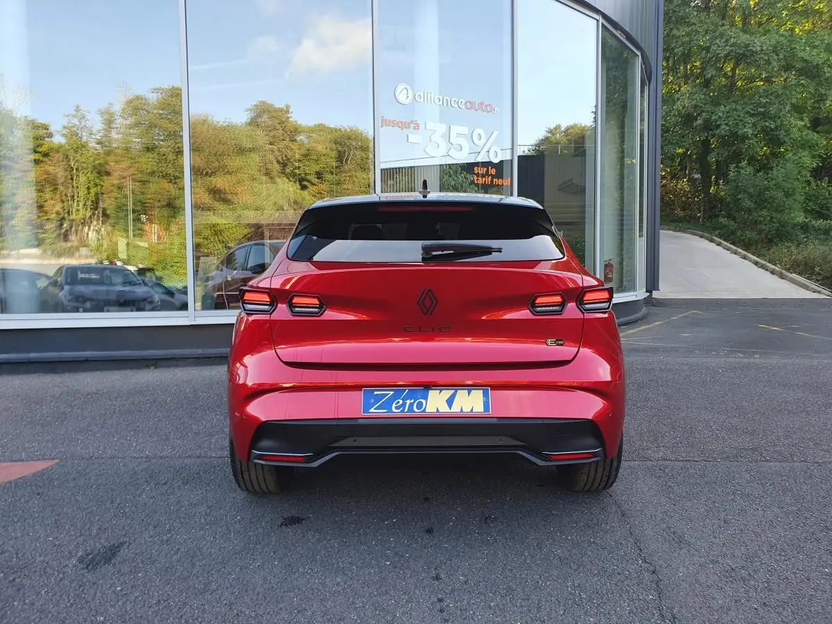 Vue arrière d'une Renault Clio VI rouge absolu avec feux LED distinctifs et plaque d'immatriculation Zéro KM.