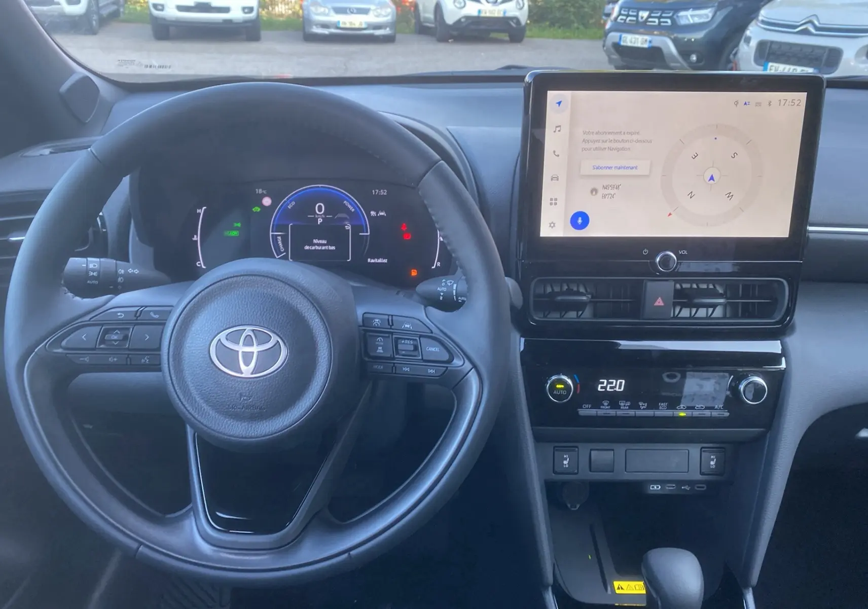 Vue intérieure frontale du tableau de bord et volant cuir noir de la Toyota Yaris Cross hybride 130 Design Plus 2026.